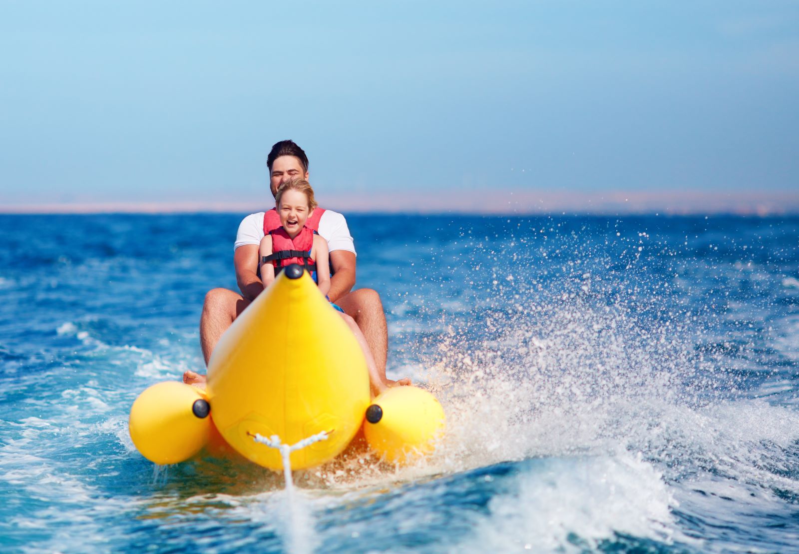dad and daughter on a banana boat